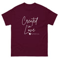 Lay flat image of women’s Christian short sleeve t-shirt in maroon showing Created in Love script lettering and Genesis 2:22 heart and cross