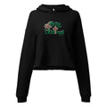 Flat lay front view of women’s Christian cropped hoodie in black featuring green script text “Merry Christmas” with snow accents, the “T” in Christmas designed as a cross, green script “Luke 2:11,” and Christmas flower accents.