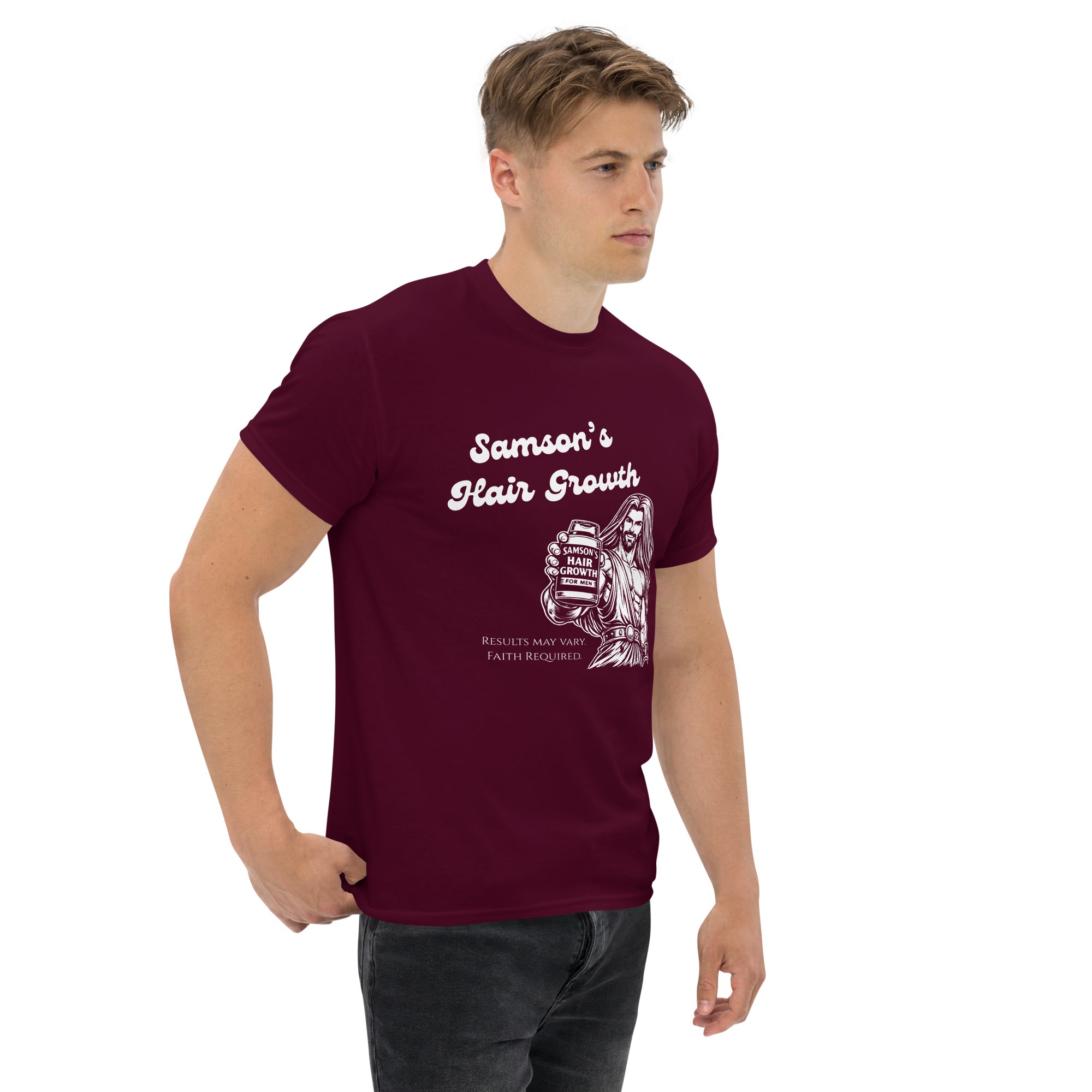 Male model turned slightly to the right wearing a maroon men’s Christian humor t-shirt showing the full front design of Samson holding a bottle labeled “Samson’s Hair Growth for Men” with the text “Samson’s Hair Growth” and fine print that reads “Results may vary. Faith Required.”