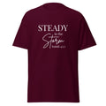 Maroon women’s Christian t-shirt lay flat front view featuring the text “STEADY in the Storm Isaiah 43:2” with Storm in a handwritten script style and the rest in block lettering