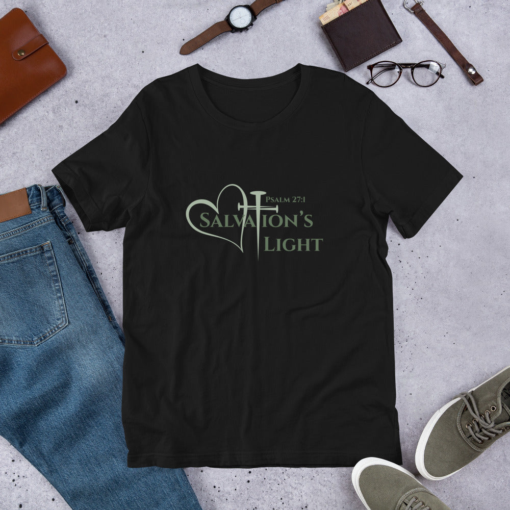 Flat image of a black short sleeve t-shirt from the Salvation’s Light Signature Collection, featuring Psalm 27:1 and the word “Salvation’s Light,” with the T designed as a sage green three-nail cross and accompanied by a sage green heart styled with jeans, sneakers and glasses