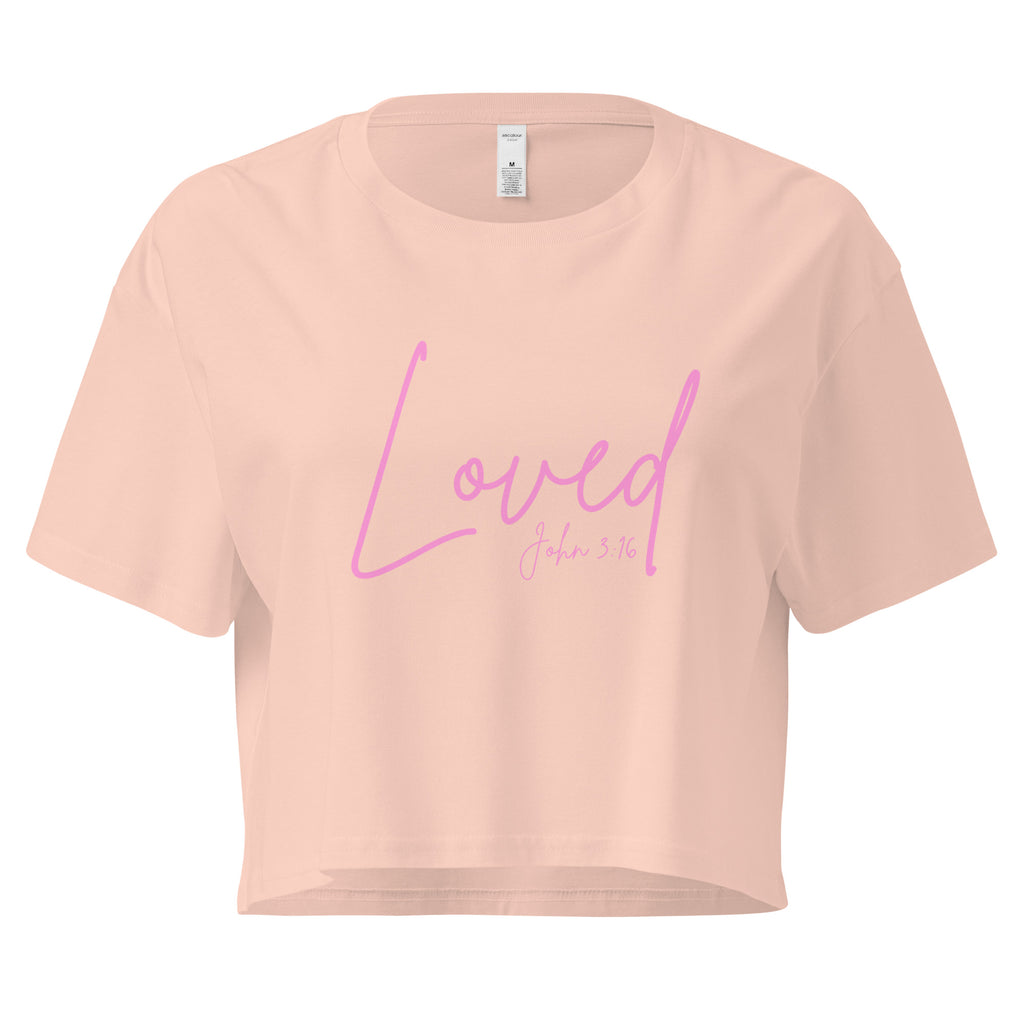 Lay flat front view of women’s cropped Christian top in pale pink with the word Loved in pink script lettering and John 3:16 printed beneath