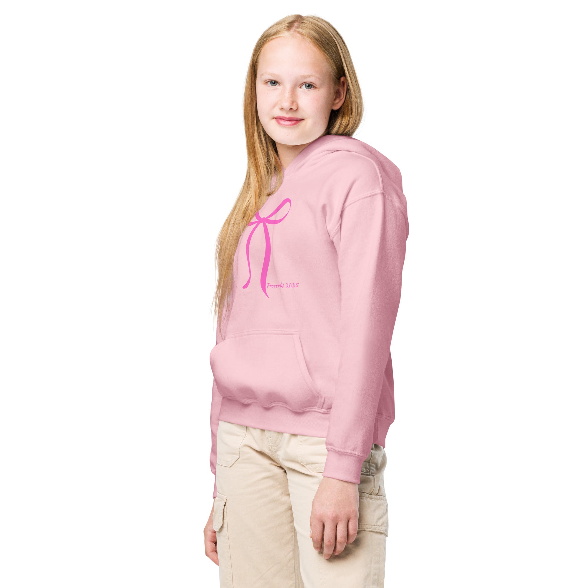 Young girl model wearing a light pink Christian kids hoodie featuring a pink bow and Proverbs 31:25 scripture on the front
